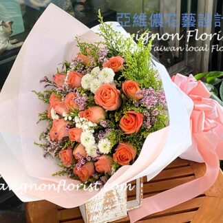 Detail of orange rose petals and complementary flowers arranged in a clean, contemporary bouquet.