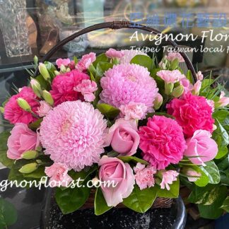 粉色系花材搭配康乃馨、玫瑰與菊花的桌上型花籃,風格溫柔大方,適合家庭送禮