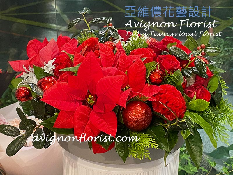 Lively Christmas flower arrangement with roses and poinsettias